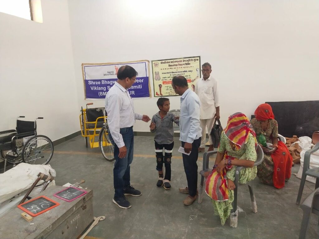 In this image a doctor take advice to the young disable boy through viklang pension scheme.