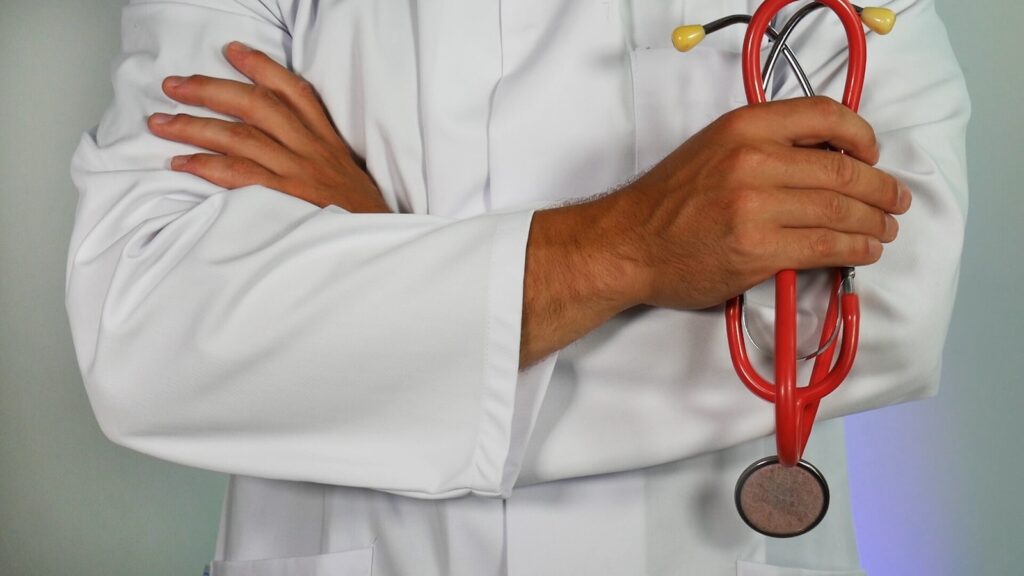 doctor holding red stethoscope waiting upon you